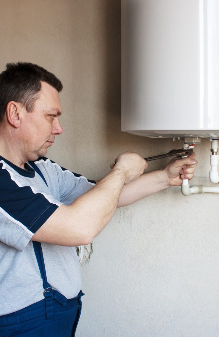 man repairing a water heater